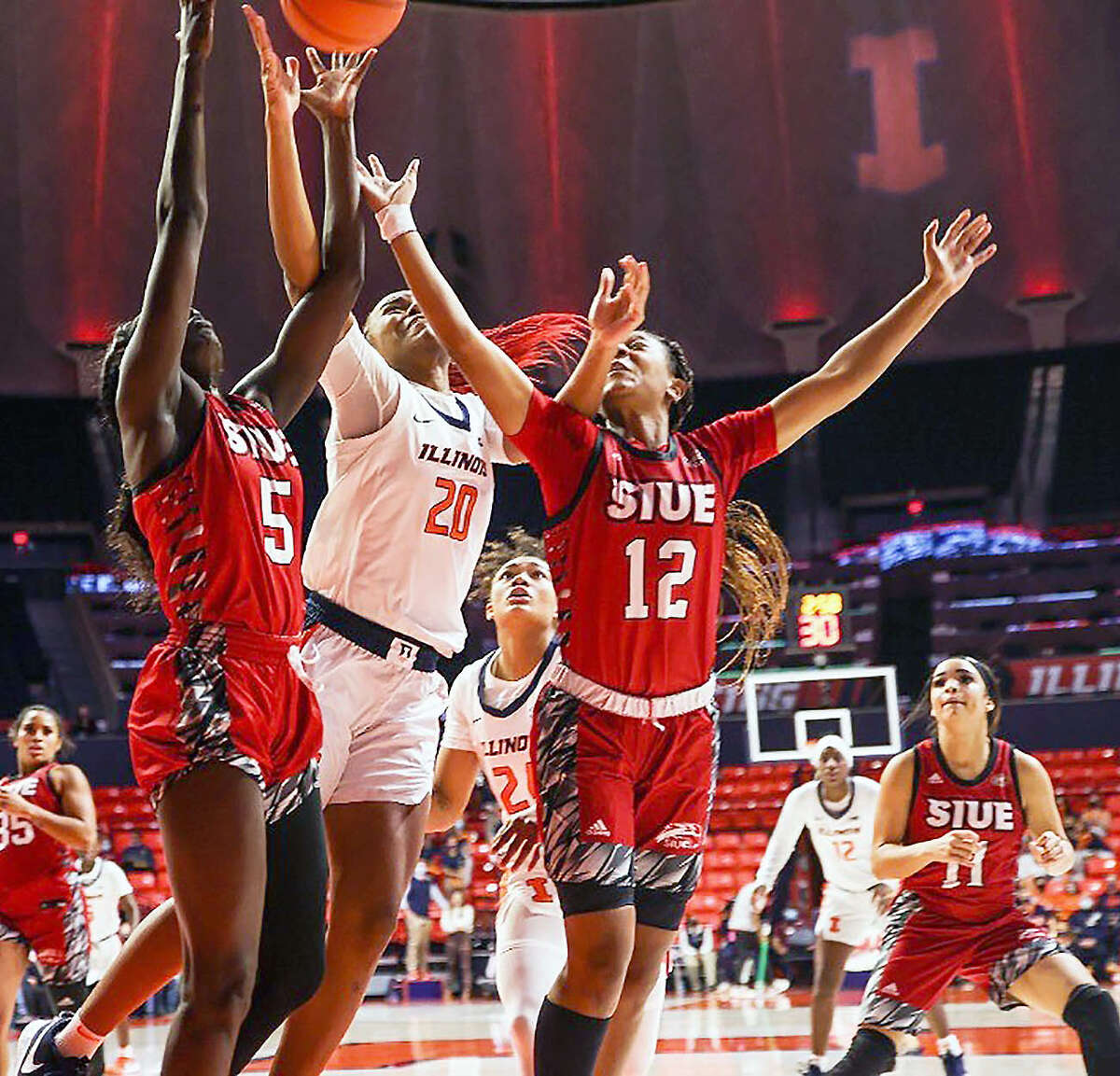 Erika Porter of Illinois (20) tries to puts up a shot between SIUE's Ajulu Thatha (5) and Mikia Keith (12) Thursday night at State Farm Center in Champaign. Also pictured is SIUE's Mikayla Kinnard (11).