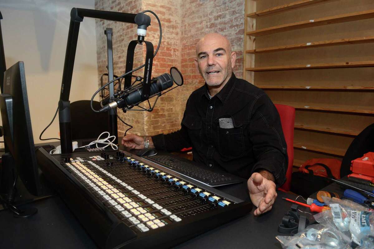 WPKN General Manager Steve di Costanzo speaks while sitting in one for the broadcast studios in the radio station’s new location in downtown Bridgeport.