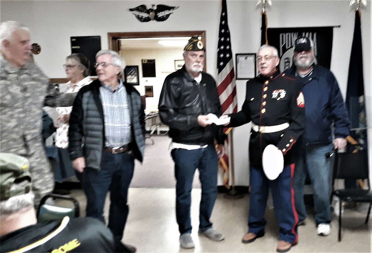 Members of the River Valley Car Club of Big Rapids present a check for $1,000 to the local AMVETS Post 1941 for veterans relief fund. 