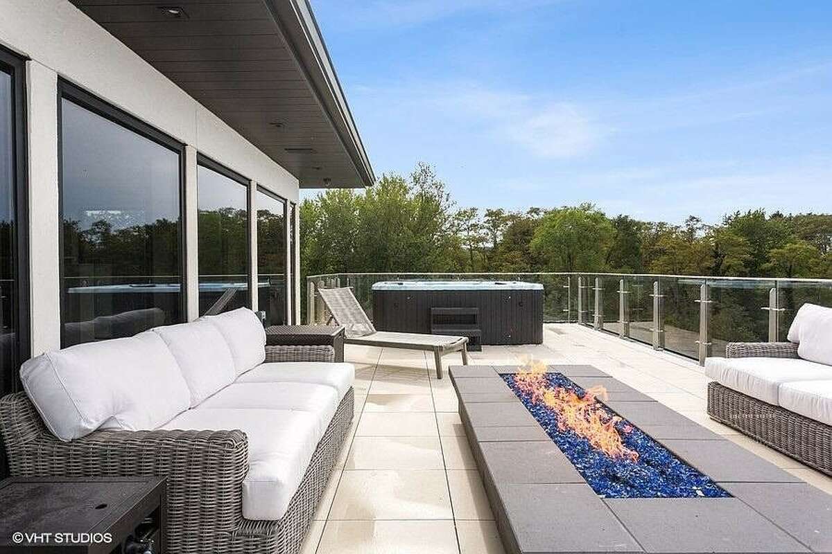 Rooftop deck with fireplace, seating and hot tub.