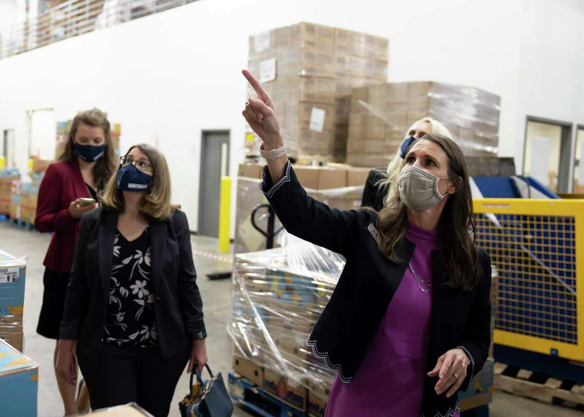 Kristine Marlow, right, CEO and President of the Montgomery County Food Bank, leads a tour for the Huntsman Corporation during a funding acceptance event at the Montgomery County Food Bank, Friday, Feb. 26, 2021, in The Woodlands. Huntsman Corporation were able to raise over $600,000 donated half to two nonprofits in Montgomery County.