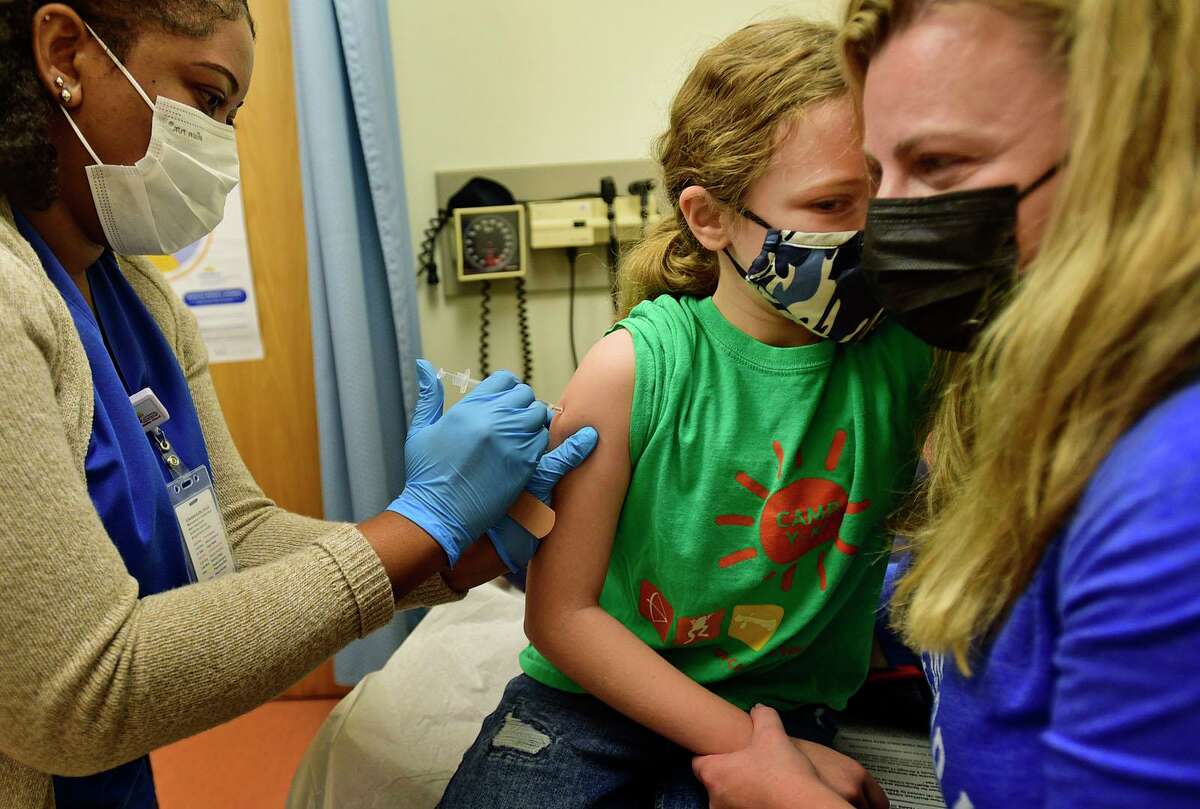 Registered Nurse Nichelle Dyer administers the COVID-19 vaccine to local children including Ava Spergel, 10, as her mom, Elvira Spergel, assists during the Norwalk Community Health Center clinic Saturday, November 13, 2021, in Norwalk, Conn.