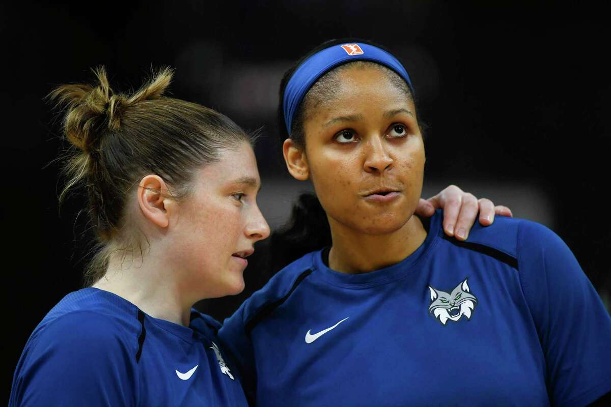 Minnesota Lynx guard Lindsay Whalen, left, talks with forward Maya Moore before the team’s WNBA game against the Los Angeles Sparks in 2018.