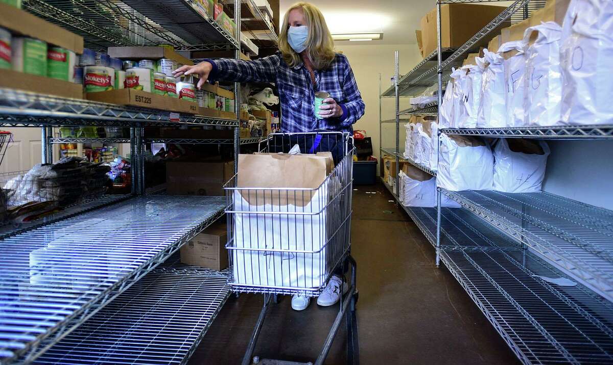 Volunteers including Laura Devens at Person-to-Person work to ready bags of food for their clients Friday, November 19, 2021, at their facility in Darien, Conn. In the lead-up to Thanksgiving, Person-to-Person is dealing with a “perfect storm” of costs for the lower Fairfield County-based food assistance organization, which is reporting that expenses are up 140 percent from the same time period in 2020.