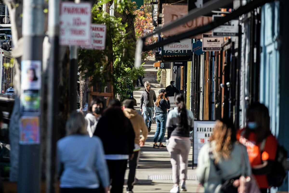 行人沿着旧金山海耶斯谷附近的海耶斯街行走。该地区受到大流行的影响，企业关门，犯罪率上升。但近几个月来，该社区已经反弹。