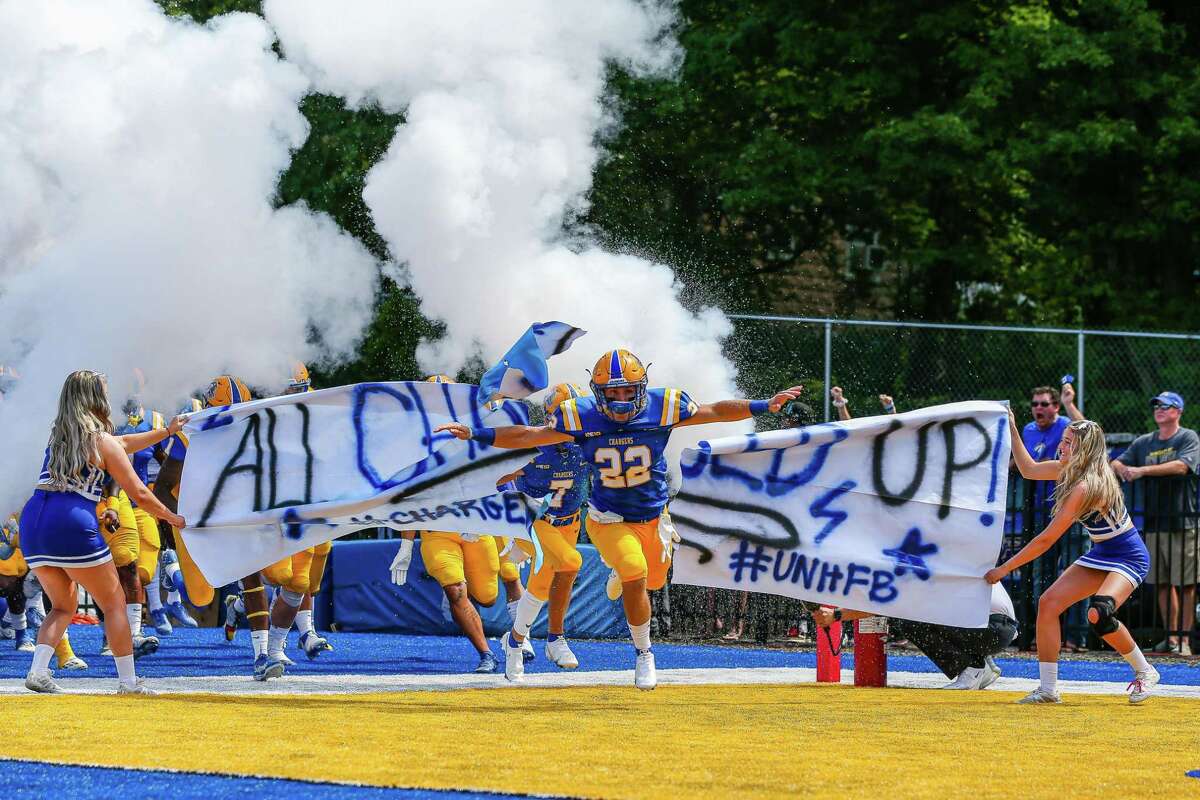 Brett Huber (22) of Milford leads the University of New Haven football team onto the field.