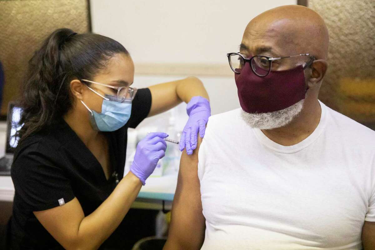 New Providence Baptist Church Senior Pastor Michael Gilmore receives his COVID-19 vaccine booster shot at a pop-up vaccine booster clinic at New Providence Baptist Church in the Ingleside neighborhood of San Francisco.