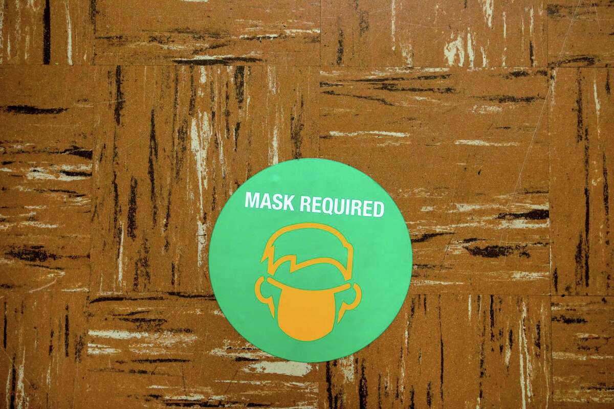 A sticker reminding folks to wear a mask has been placed on the floor at Madison Park Academy Primary on Thursday, March 25, 2021, in Oakland, Calif. The school is preparing to reopen on Tuesday.