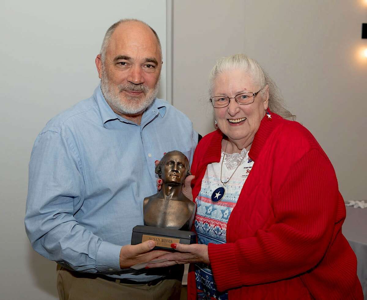 Barry Casey, president of the National Independent Flag Dealers Association, presents the George Washington Ward for Excellence to Susan Wells, Stars for Troops founder.