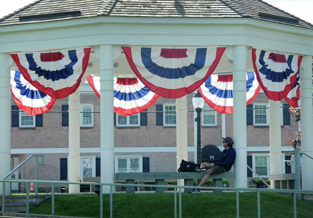 A man sits under the Norwalk Green Gazebo which is festooned for Memoraial Day weekend during a hot Saturday monring May 26, 29018, in Norwalk, Conn.