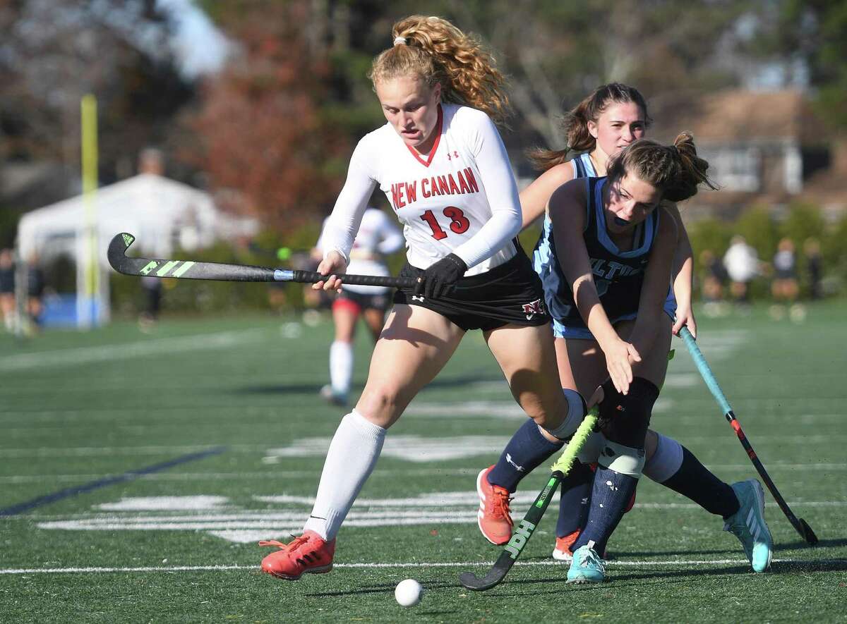 New Canaan’s Zoey Bennett, left, is challenged for the ball by Wilton’s Elizabeth Kendra during the Rams’ 3-1 victory in the CIAC Class L field hockey championship at Wethersfield High on Saturday.