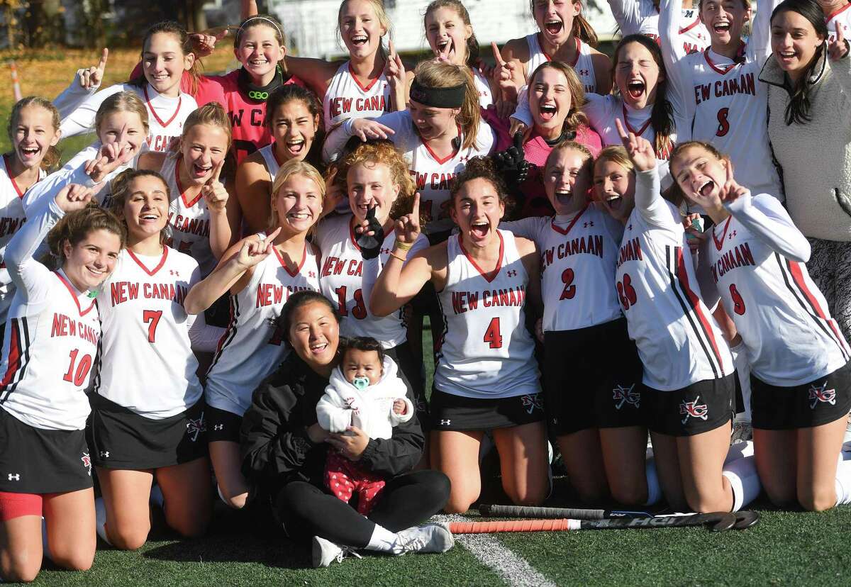 New Canaan players celebrate following their 3-1 victory over Wilton in the CIAC Class L field hockey championship at Wethersfield High on Saturday.