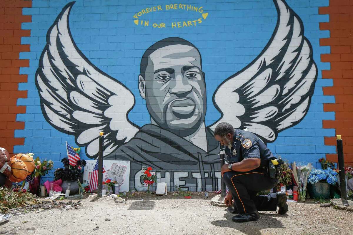 Sheriff Deputy Anthony Glenn paid his respects to George Floyd in front mural made in his honor outside the Scott Food Mart corner store in Houston's Third Ward. Monday, June 8, 2020, in Houston.