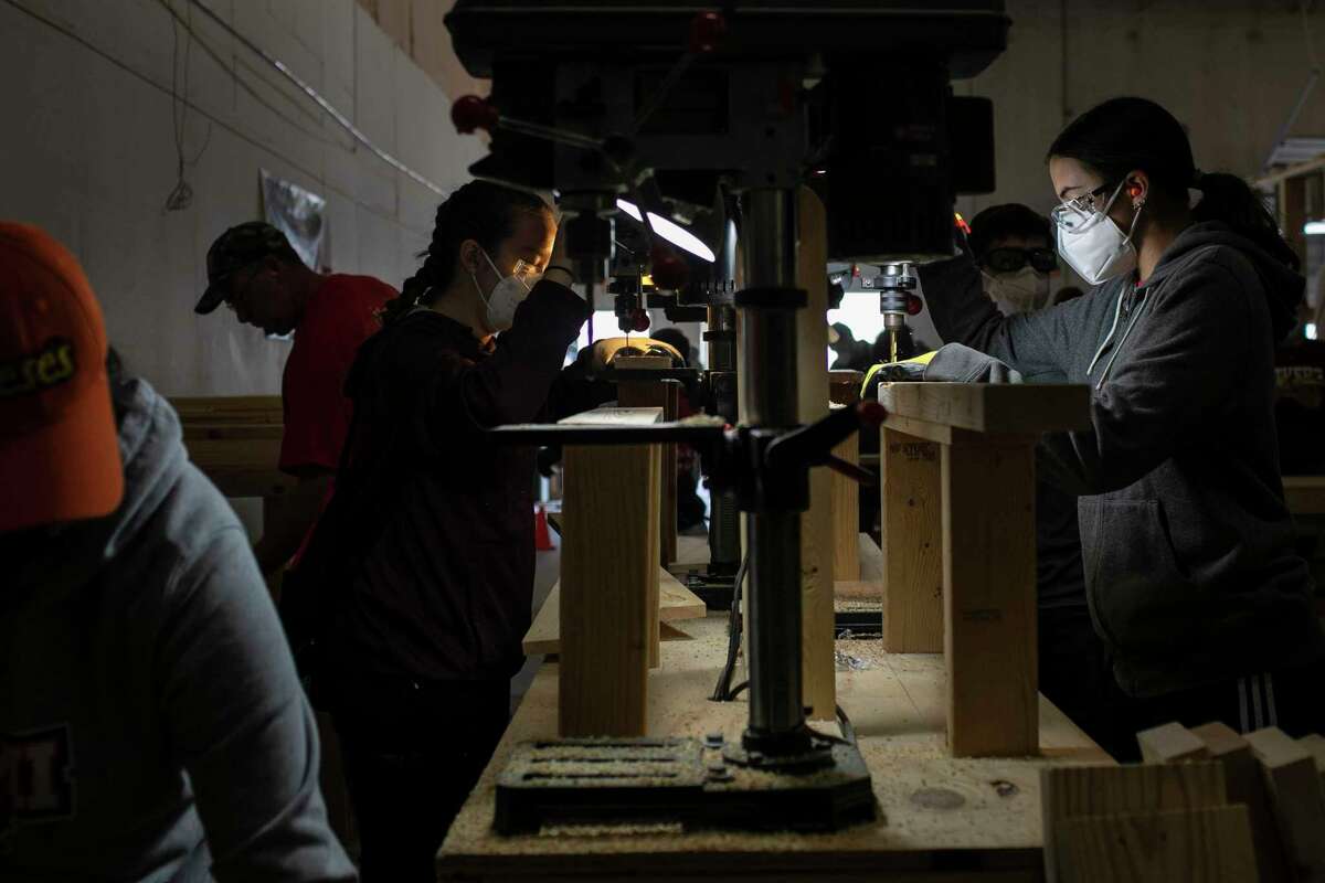 Volunteers use drill presses to make beds at the Sleep in Heavenly Peace warehouse in San Antonio, Texas, on Nov. 20, 2021. The Ray D. Corbett Junior High School girls’ basketball team partnered with the Fellowship of Christian Athletes Club at Corbett to build bunk beds for the approximately 30 students in the Schertz-Cibolo-Universal City ISD who do not have a bed of their own.