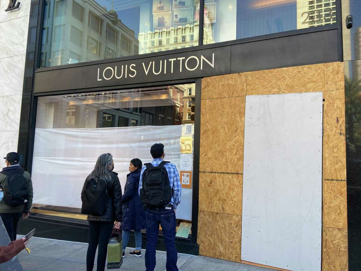 2021年11月20日，周六，联合广场的游客们在查看受损的路易威登商店，小偷在前一天晚上洗劫了旧金山的商店。