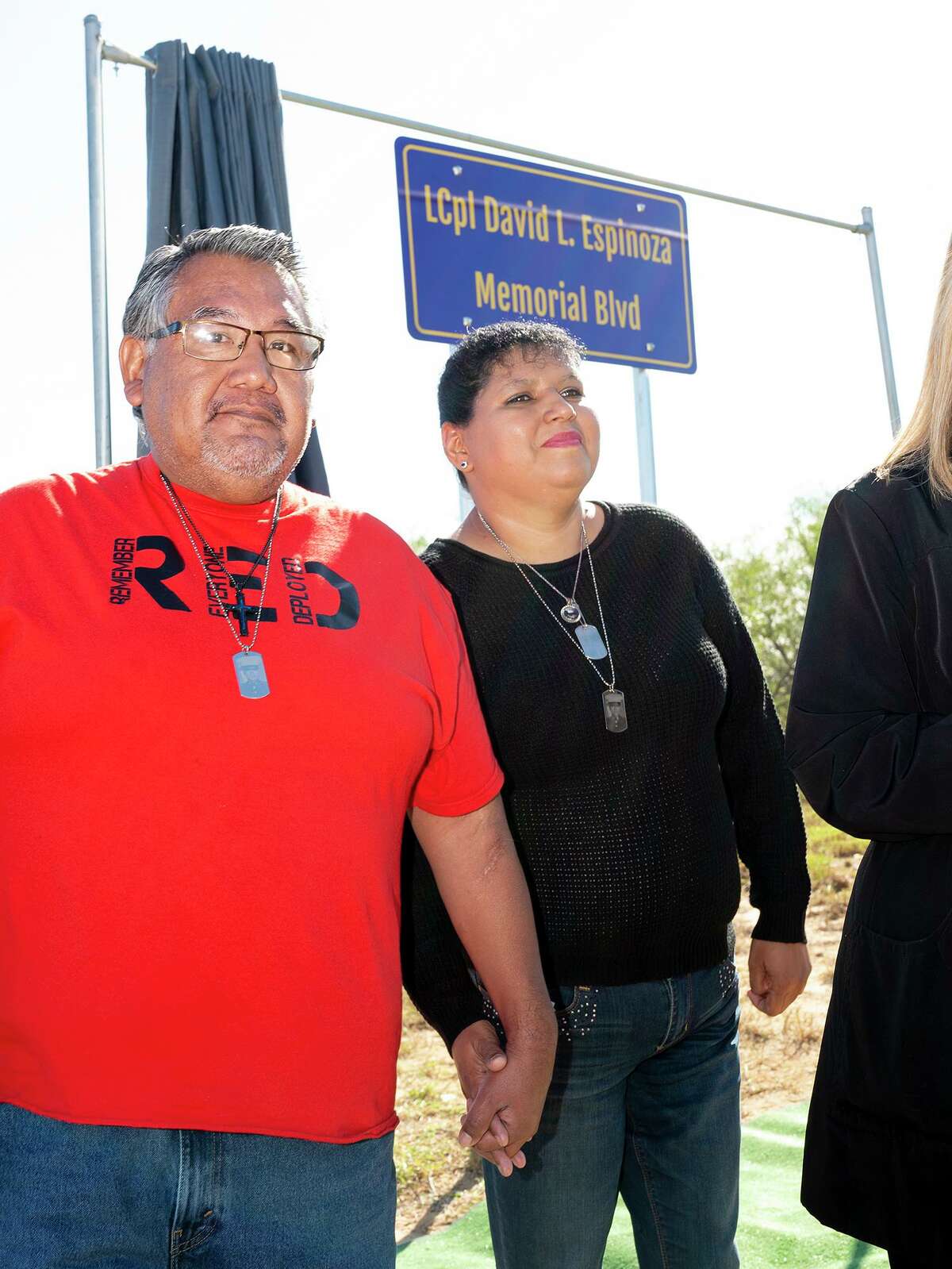 The parents of the late Lance Cpl. David Lee Espinoza -- Elizabeth Holguin and Victor Manuel Dominguez -- stand next to the recently revealed sign renaming Cielito Lindo Blvd to LCpl David L. Espinoza Memorial Blvd., Friday, Nov. 19, 2021 during a dedication ceremony.