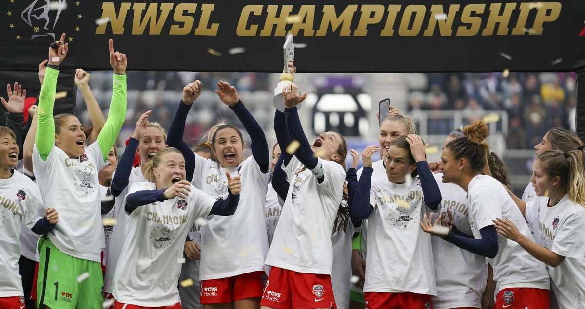 Washington Spirit's Andi Sullivan, center, lifts the trophy as they celebrate after defeating the Chicago Red Stars in the NWSL Championship soccer match, Saturday, Nov. 20, 2021, in Louisville, Ky. (AP Photo/Jeff Dean)