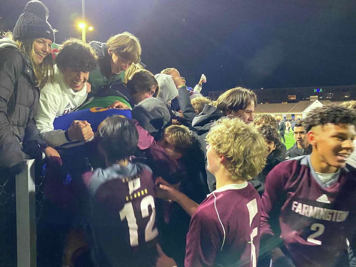 Members of the Farmington boys soccer team celebrate their CIAC Class LL championship after defeating Cheshire Saturday night at Dillon Stadium.