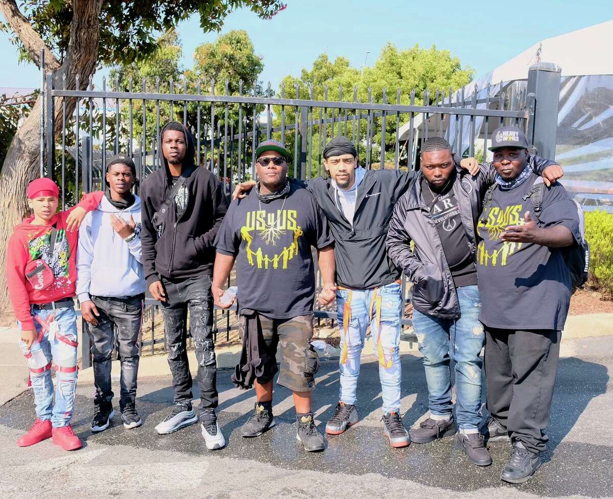 Damien Posey, center, stands with a group of young entrepreneurs from across San Francisco that his organization worked with to provide legitimate pathways to success for local youth.