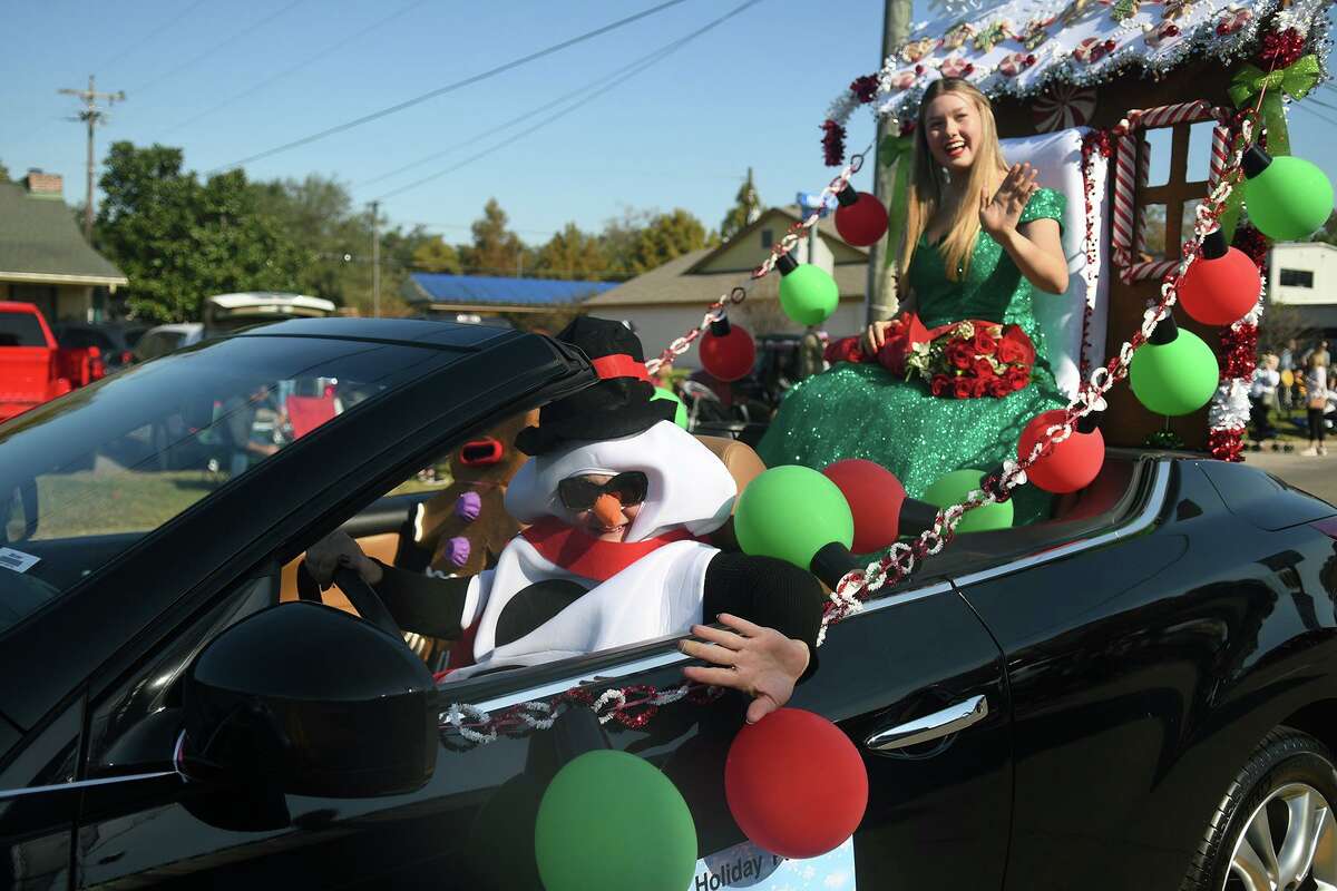 Tomball Memorial High School junior and Miss Tomball 2022 contestant Addie Cox, 16, right, being chauffered by her snowman mom, Rhonda, waves to the crowd during the 56th Annual Tomball Holiday Parade which featured about 150 entries marching, performing and driving down Main Street on Saturday, Nov. 20, 2021.