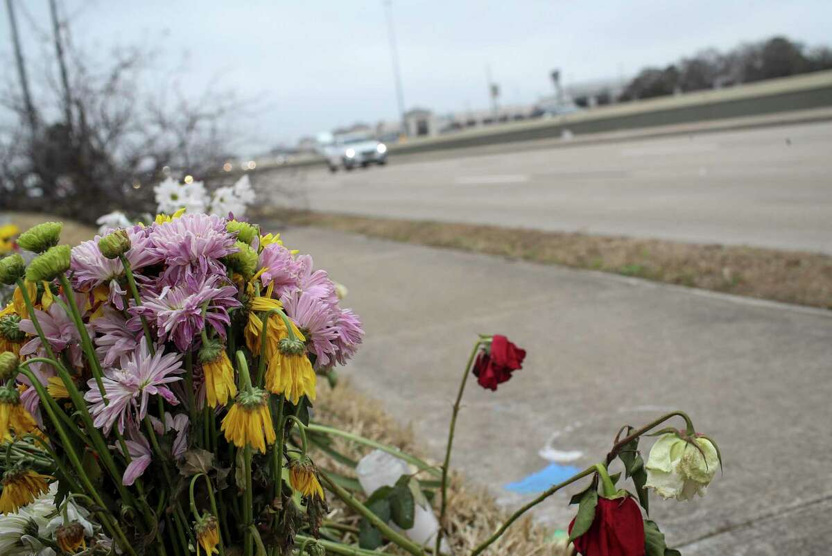 Traffic passes by a memorial at the site of a crash that resulted in the deaths of three people.