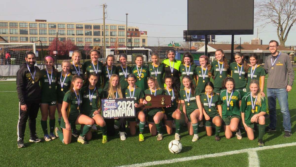 Members of the Holy Cross girls soccer team celebrate after winning the CIAC Class S championship with a 3-2 victory over Northwest Catholic Sunday at Dillon Stadium.