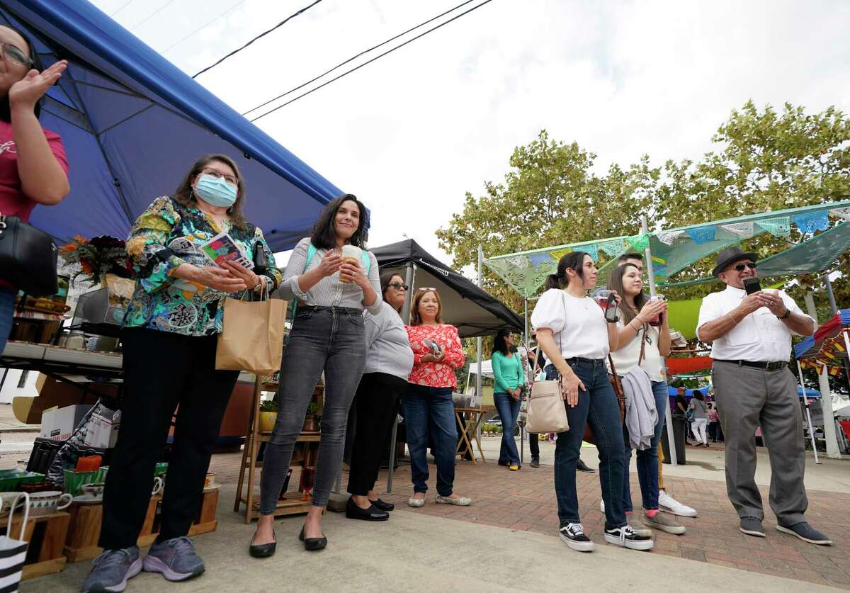 People applaud as a poem is read that is one of East End Postales, a series of English and Spanish postcards that reflects the East End’s natural spaces, during the East End Farmer’s Market Sunday, Nov. 21, 2021 in Houston. The postcards featuring artwork and poetry are printed on seed paper that can be planted.