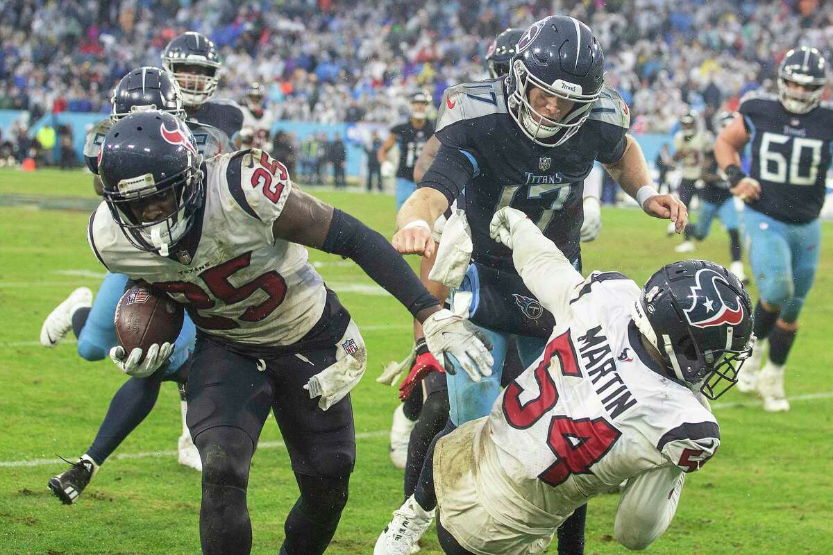 Houston Texans cornerback Desmond King II (25) is knocked out of bounds as he runs past Tennessee Titans quarterback Ryan Tannehill as he returns an interception of a Tannehill pass during the second half of an NFL football game Sunday, Nov. 21, 2021, in Nashville.