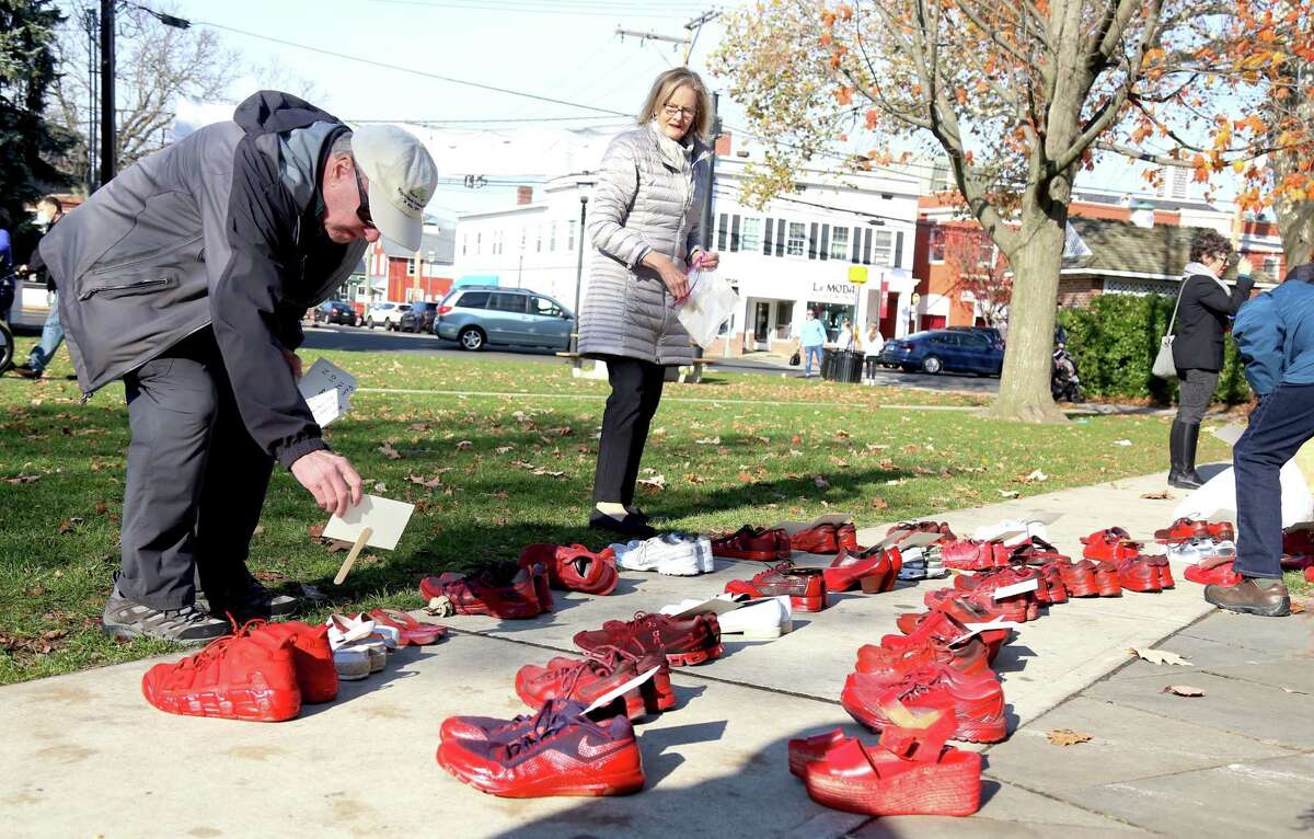 Tim Bezler, of Fairfield, puts a name on a pair of shoes in remembrance.