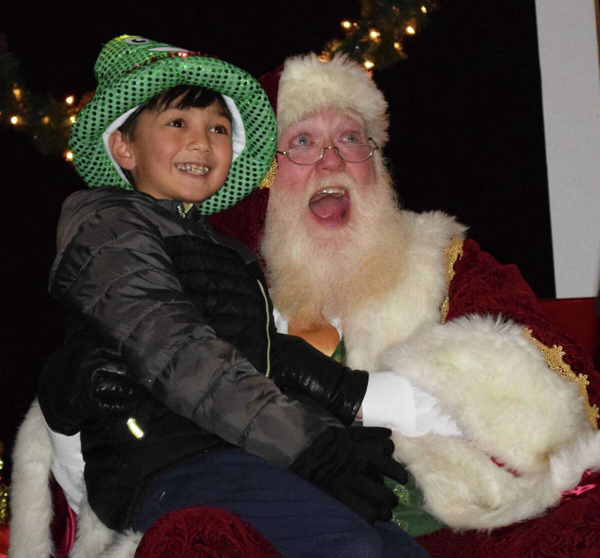 Spectrum/The annual lighting of the trees on the Village Green in New Milford was held Nov. 24, 2018. The event was held by the Greater New Milford Chamber of Commerce. The trees are put up annually by the United Methodist Men at the New Milford United Methodist Church. Above, Joshua Violette, 9, and Santa pose for a photograph following the lighting of the trees.