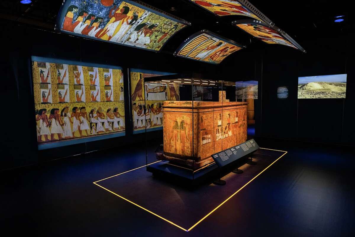 The coffin of the workman Sennedjem, displayed beside images of his burial chamber at HMNS. 