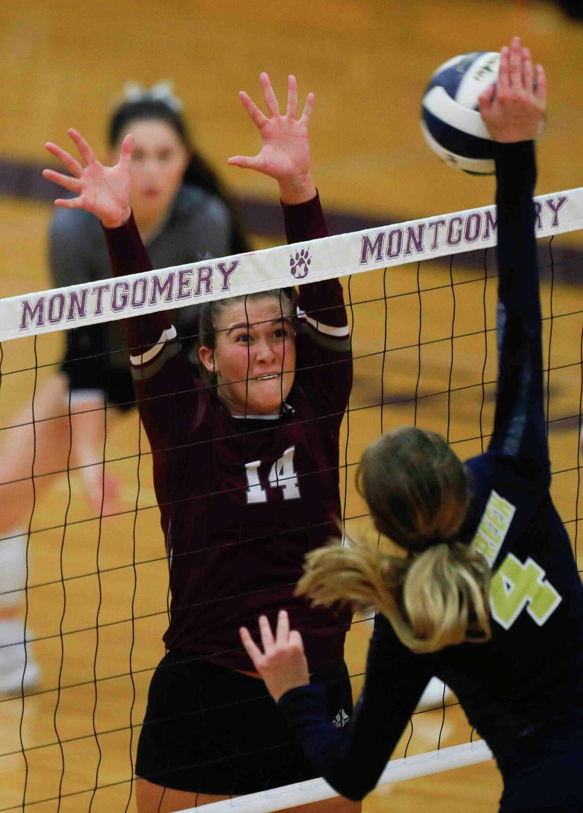 Magnolia middle blocker Alex Bull (14) blocks a shot by Lake Creek outside hitter Payton Woods (4) in the third set of a Region III-5A bi-district volleyball playoff match at Montgomery High School, Tuesday, Nov. 2, 2021, in Montgomery.
