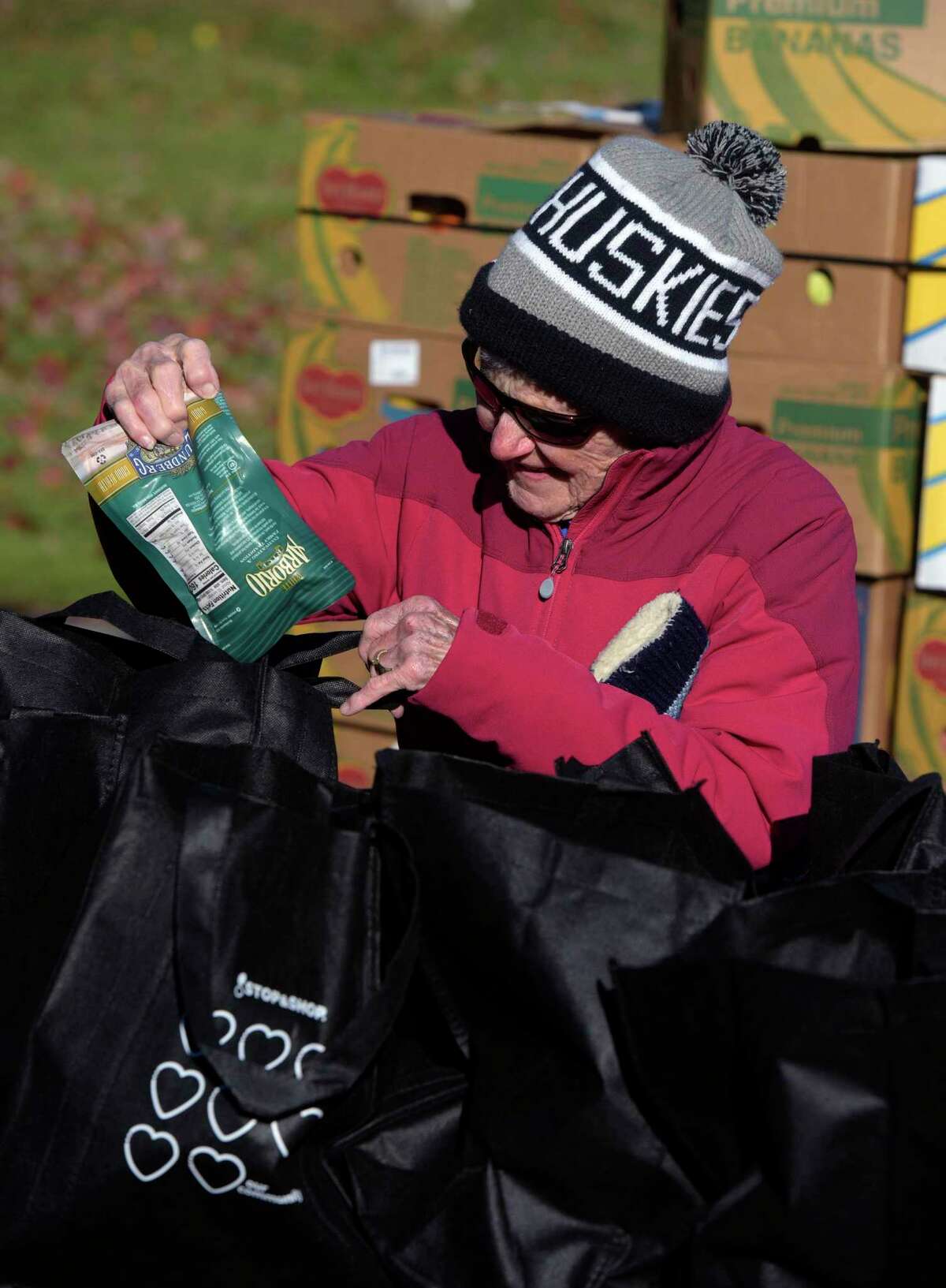 Volunteer Becky Strominger, of Ridgefield, packs bags of food at St. Andrew's Church on Friday morning. Food delivered by CT Foodshare was distributed by Ridgefield Social Services on Friday morning, November 19, 2021, Ridgefield, Conn.