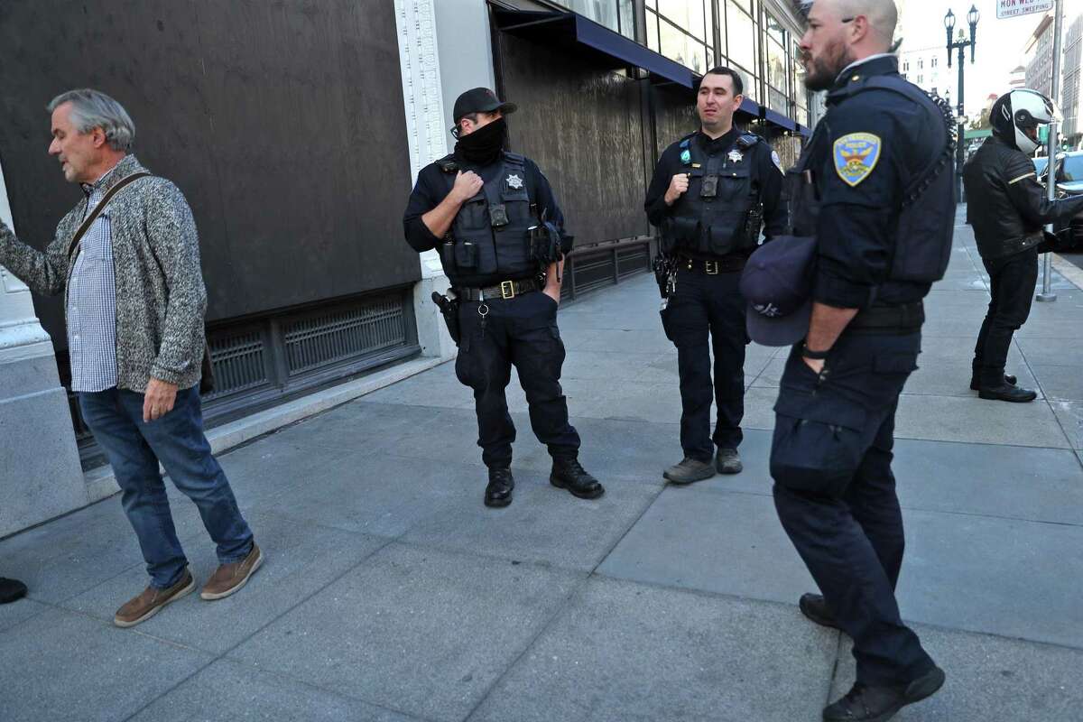 The police department, in conjunction with the city controller’s office, will conduct an analysis of a 50-year-old local law that was intended to regulate the private security firms. This file photo shows SFPD officers standing outside the Harry Winston store at corner of Post Street and Grant Avenue in San Francisco on Monday, November 22, 2021.