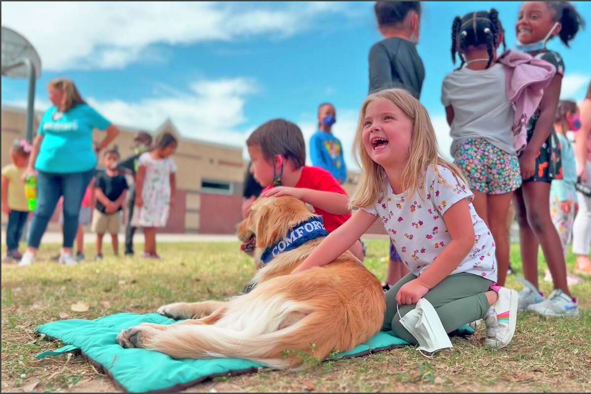 Walker kindergarten student Violet Miller pets Skye during recess on Oct. 21. In addition to working with Taylor to accomplish certain goals, Skye helps serve as an incentive for students to remain on task, complete work and as a reward for good behavior.