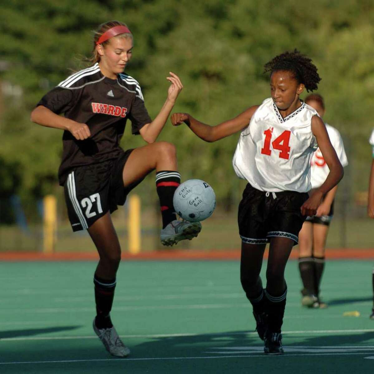 Fairfield Warde's #27 Elise Finzi, left, controls the ball as Central's #14 Amanda McKenzie comes in to intercept, during soccer action at Central High School in Bridgeport, Conn. on Tuesday September 21, 2010.