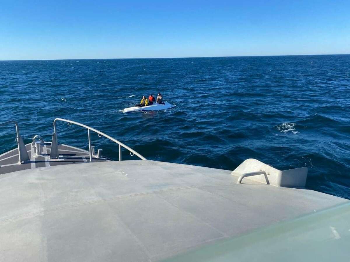 Coast Guard personnel rescue three fishermen from their capsized boat Monday off Tomales Bay.