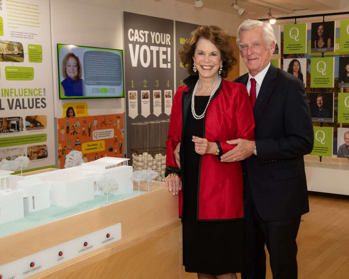 Dede and Jim Bartlett celebrate donating $3 million for the new library, as they stand by a model of it.