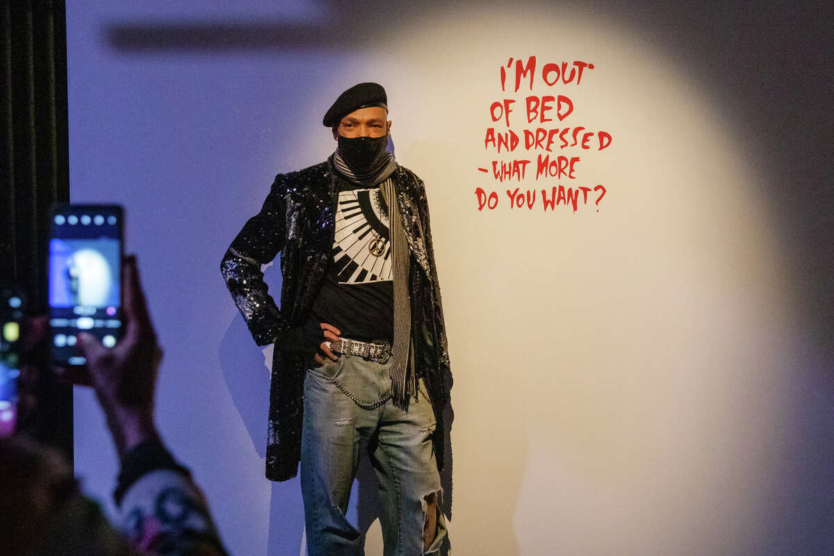 Theo McKinney poses with one of the interactive pieces of artwork at the "Art of Banksy" unauthorized private collection exhibit at the Palace of Fine Arts in San Francisco on Nov. 21, 2021.