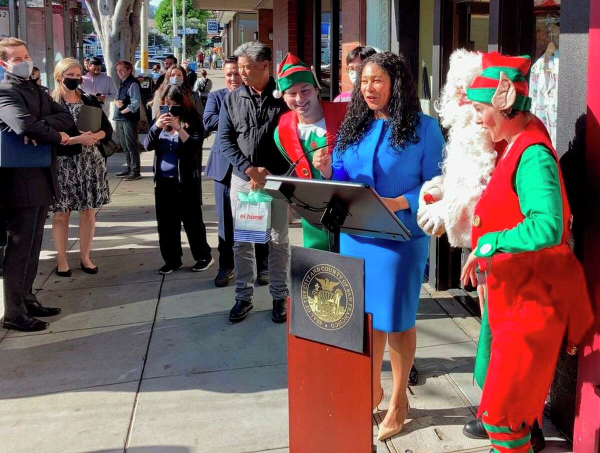 S.F. Mayor London Breed, flanked by Santa Claus and a pair of elves, promotes Christmas shopping on Chestnut Street.