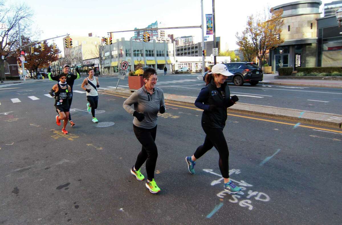 Members of the Valley Forge Running Club Alicia Gerbert, in front at left, and Heather Marcellis, at right, start off for their weekly 6-mile run from Winfield Street Coffee in downtown Stamford on Nov. 20.