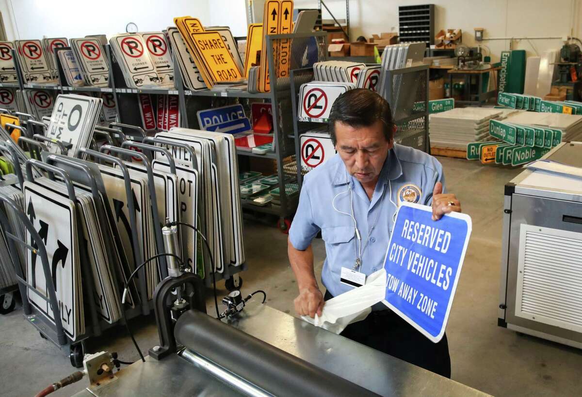 Isaias Gomez makes a sign at the city’s sign-production shop near I-10 and Shepherd. Gomez said he has worked at the shop for 20 years.