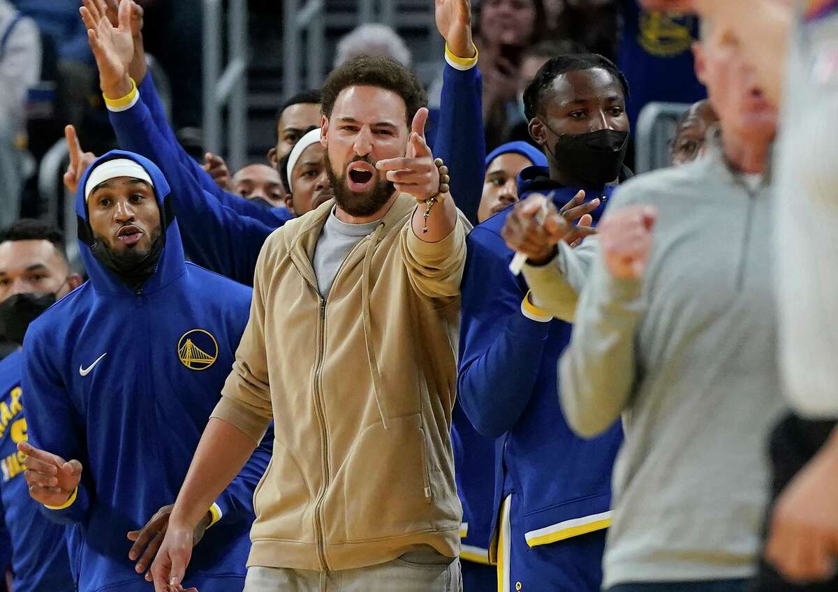 Injured Golden State Warriors' Klay Thompson, center, gestures during the second half of an NBA basketball game against the Oklahoma City Thunder in San Francisco, Saturday, Oct. 30, 2021. (AP Photo/Jeff Chiu)