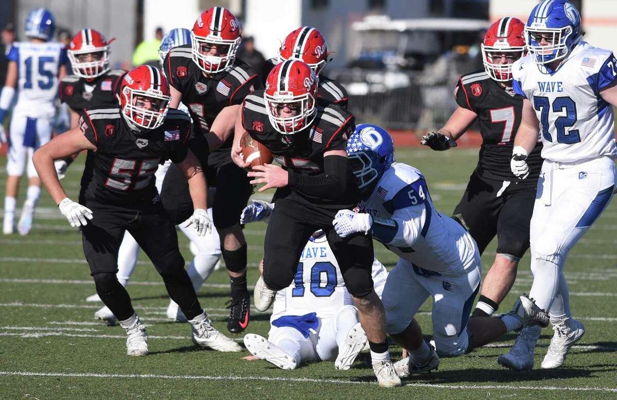 New Canaan's Kieran Buck (12) tries to get away from Darien's Connor Fay (54) during the Turkey Bowl football game at Stamford's Boyle Stadium on Thanksgiving, Nov. 22, 2018.