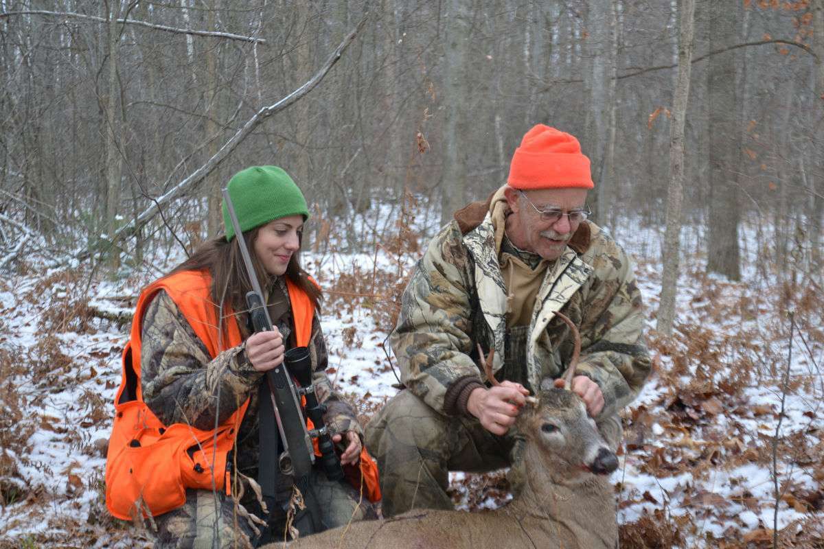 FILE - Ken Haustein of Midland and his daughter Corie Oberson of Auburn admire the three-point buck Haustein shot as the pair hunted together in Midland County in 2020.