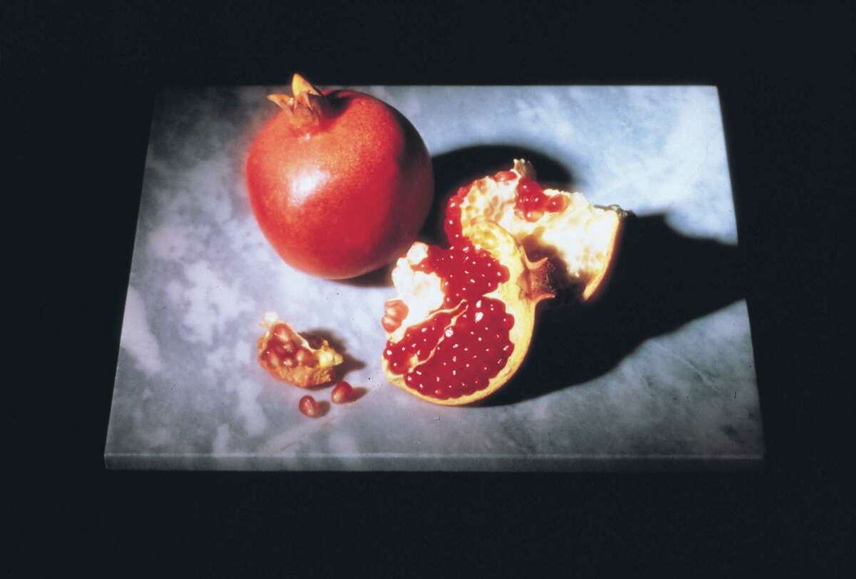 Leathery skin of a pomegranate reveals juice-bearing seeds.