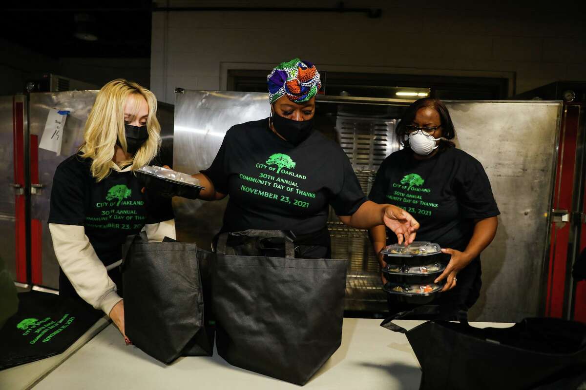 Alexia Hermann, left, Jualeah Shaw, center, and Latascha Magness-Cotton pack meal kits during the 30th Annual Community Day of Thanks at the Oakland Marriott City Center on Wednesday, November 23, 2021. The annual event is hosted by the City of Oakland’s Human Services Department.