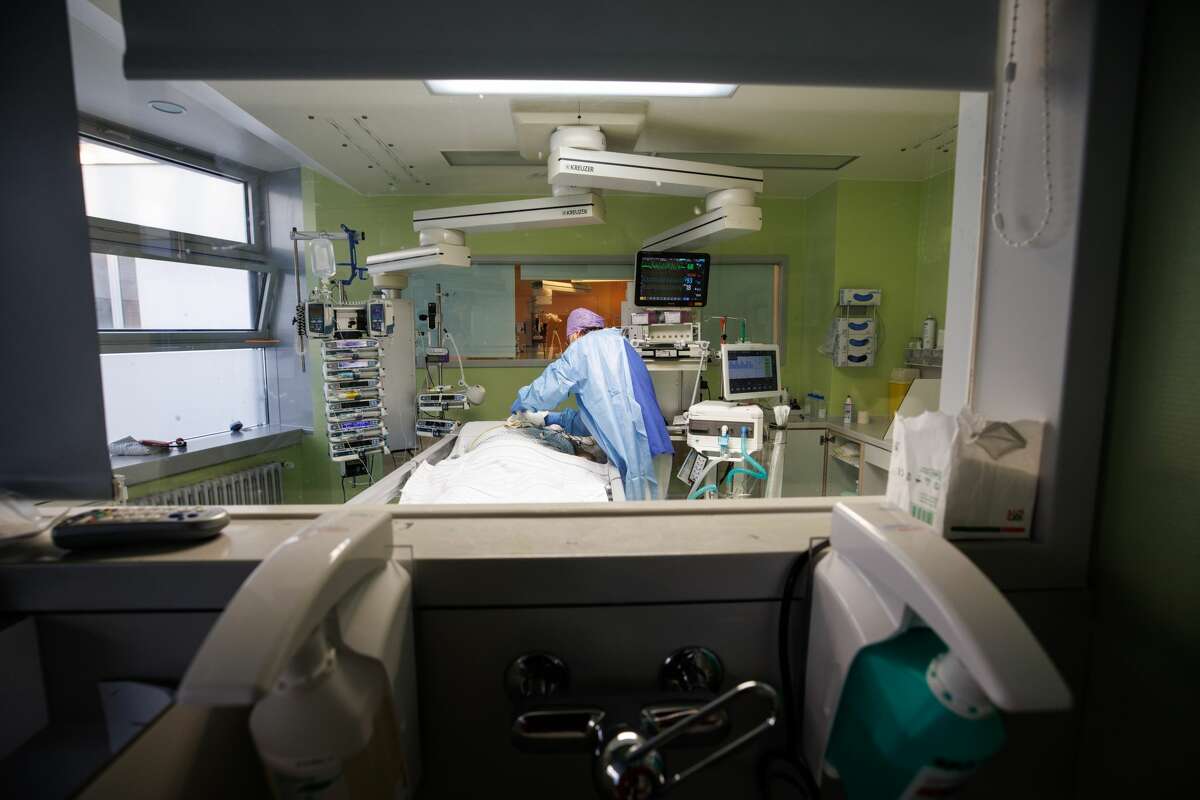 Lorenz Nowak, head physician of the Clinic for Intensive Care Medicine, works in protective clothing in an intensive care room. Investigators hope to gain insight into the long-term health consequences of COVID-19, including how it affects brain health. 