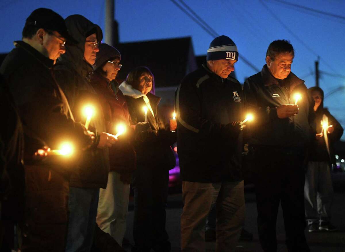 Friends, neighbors, and concerned citizens attend a candlelight vigil for domestic violence homicide victim Grace Zielinska outside her former home on Root Avenue in Ansonia on Tuesday. Ansonia Mayor David Cassetti is at right.