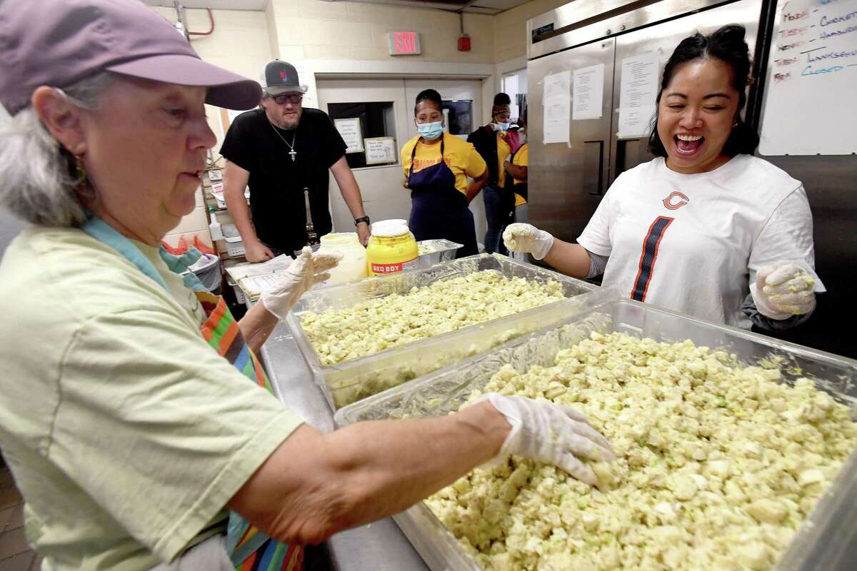 Cathy Hart (right), a volunteer with Houston's Theragood Deeds organization, jokes with Suzanne Lambremonte, while prepping potato salad for Thursday's annual Thanksgiving meal at Some Other Place Wednesday morning. Theragood Deeds volunteered to help with the final preparations, working alongside Some Other Place's usual crew of volunteers from St. Stephen's Episcopal Church. Photo made Wednesday, November 24, 2021 Kim Brent/The Enterprise